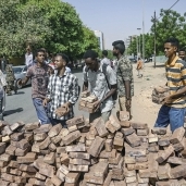 عدد من المتظاهرين يبنون المتاريس خلال اعتصامهم أمام قيادة الجيش السودانى «أ.ف.ب»