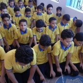 بالصور| معلم يصلي بتلاميذه في سوهاج.. وأولياء أمورهم يشيدون بالفكرة