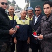عمال النظافة يقدمون الورود لرجال الشرطة