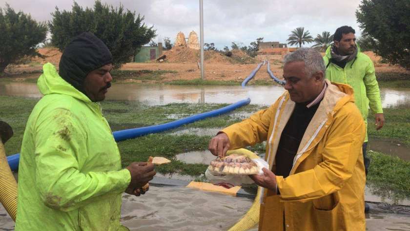 رئيس مدينة برج العرب غرب الإسكندرية يوزع الطعام على عمال كسح الأمطار