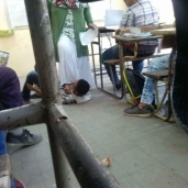 صورة لمعلمة تضع قدمها علي طالب