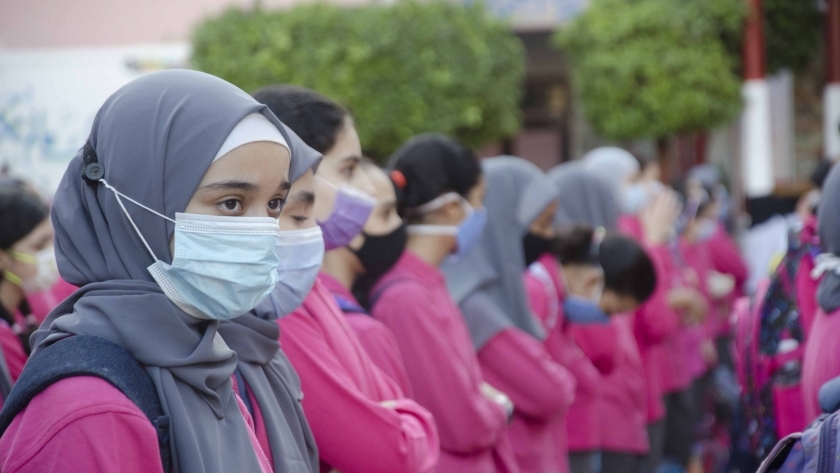 طلاب المدارس ملتزمون بارتداء الكمامات الطبية أثناء طابور الصباح