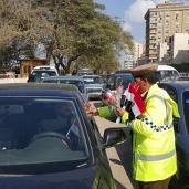 رجال الشرطة يوزعون الأعلام والورود علي مواطني بنها إحتفالا بذكري ثورة 25 يناير