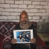 والد الشاب المختطف في ليبيا محمد حاملا صورة نجله