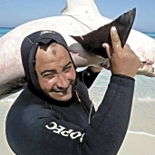 «خالد» يحمل سمكة القرش