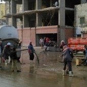 عمال النظافة يشاركون في شفط مياه الأمطار من شوارع الفيوم
