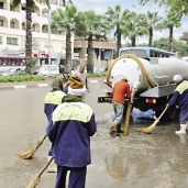 عمال محافظة الجيزة يسحبون المياه من الشوارع