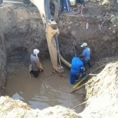 عمال شركة المياه حال قيامهم بإصلاح خط الطرد