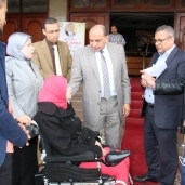 رئيس جامعة بني سويف يسلم كرسي كهربائ لطالبة من ذوي الإعاقة