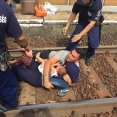 لاجئ سورى ينقذ زوجته وطفله من محاولات منع الشرطة المجرية لهم من ركوب القطار المتوجه إلى النمسا «أ. ف. ب»