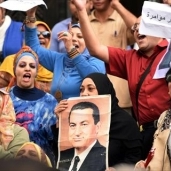 بالصور| أنصار "مبارك" يتظاهرون أمام "القضاء العالي" بالتزامن مع إعادة محاكمته