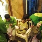 أعضاء فريق «بسمة للإيواء» أثناء تقديم وجبة لطفلة مشردة