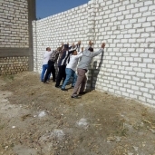 موظفين بمحلية ديرمواس يهدمون حائط