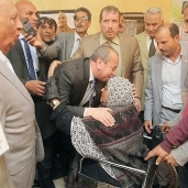 محافظ كفر الشيخ يقبل راس سيدة مسنة