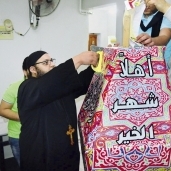 الكاهن يعلق فانوس رمضان أمام الكنيسة فى الإسكندرية