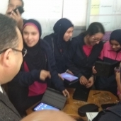 محافظ الإسكندرية يجرب التابلت ويداعب الطالبات أثناء التوزيع