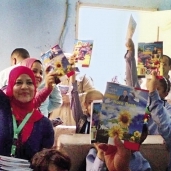 تلاميذ يرفعون كراسات المرشح وعليها صوره داخل الفصل