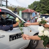 بورميون بوذيون يوزعون الورود البيضاء على المسلمين المتوجهين لأداء صلاة عيد الفطر