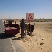 إسلام عمران وصديقه أثناء تركيب لافتات «انتبه مطب» بالفرافرة