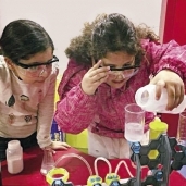 طفلتان تستمتعان بإجراء إحدى التجارب العلمية