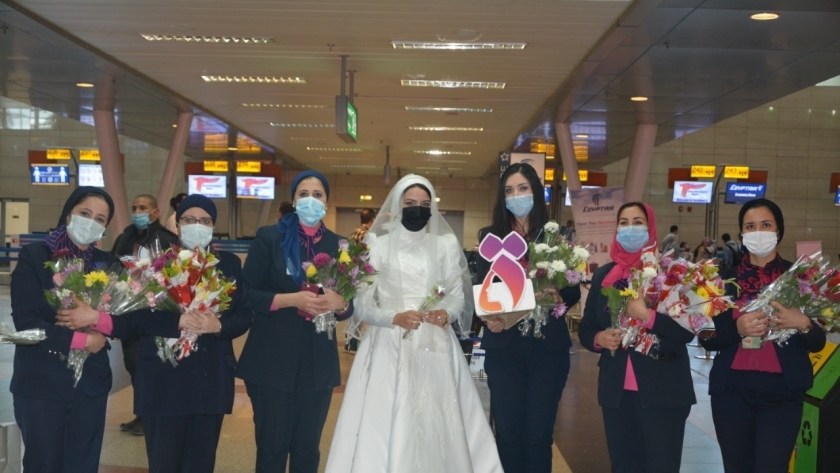 المجلس القومي للمرأة يوزع الورود على السيدات بمطار القاهرة