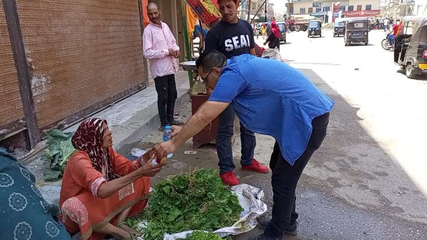 موظفو مدينة بلقاس أثناء توزيع «المياه والعصير» على البائعين