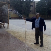 سكرتير عام محافظة سوهاج يرش فناء مدرسة بالمياه في انتظار وصول الناخبين