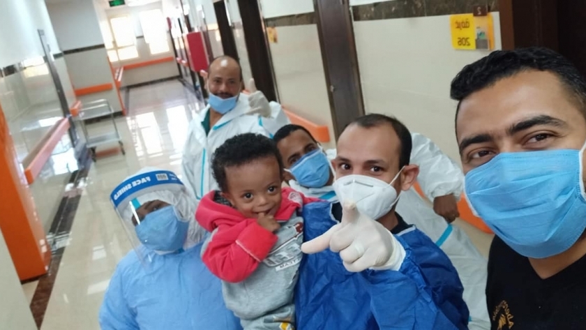 أول طفل مصاب بكورونا في الأقصر مع الطاقم الطبي