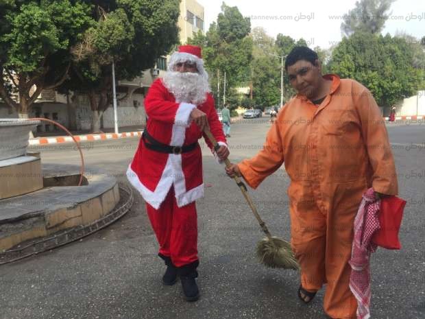 «بابا نويل» يكنس شوارع قنا ويوزع الهدايا على المارة