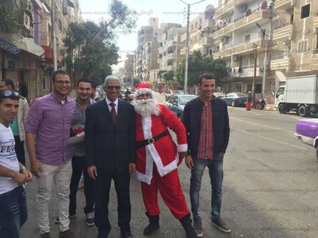 «بابا نويل» يكنس شوارع قنا ويوزع الهدايا على المارة