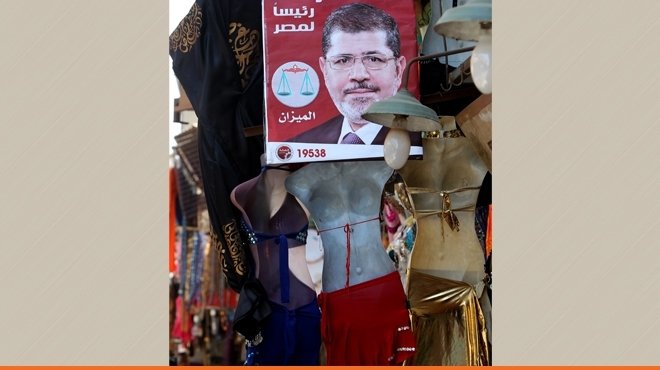 بالصور..أطرف أماكن الدعاية: مرسي يعتلي محلات الـ