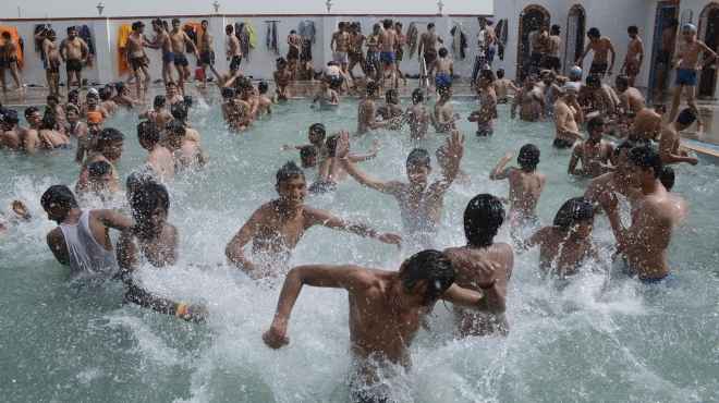  بالصور| الشباب الهندي يواجه ارتفاع حرارة الجو بأحواض السباحة العامة 