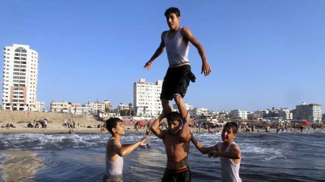  بالصور| أهالي فلسطين يتحدون رصاص الاحتلال بالسباحة على شواطئ غزة