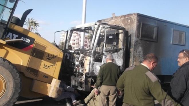 بالصور| الأمن يرفع سيارة الترحيلات التي أحرقها الإخوان بأسيوط