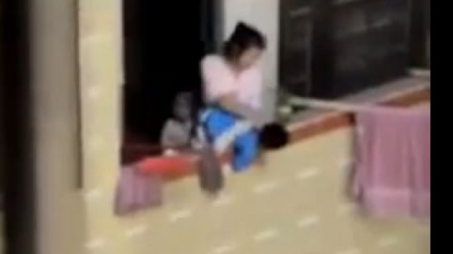 بالفيديو| صينية تهدد طفلها بإلقائه من الشرفة