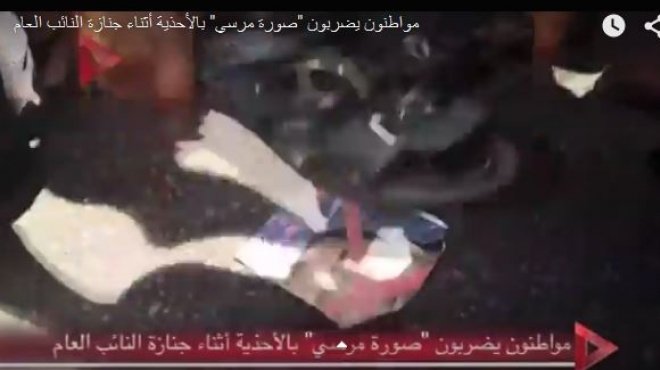 بالفيديو| مواطنون يضربون صورة مرسي بالأحذية أثناء جنازة النائب العام
