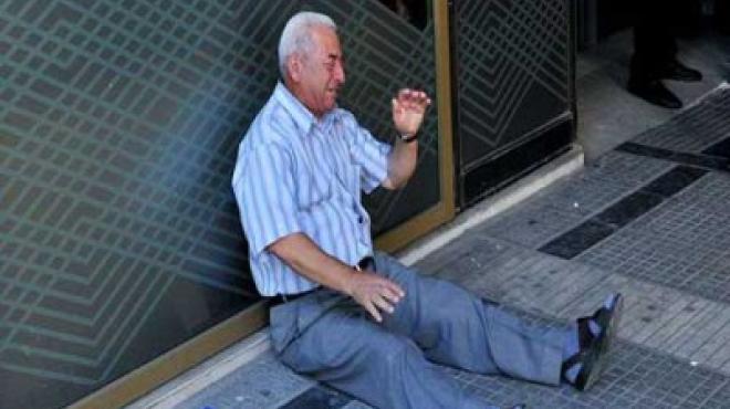 القصة الكاملة وراء صورة المتقاعد اليوناني الذي جلس يبكي عند باب البنك