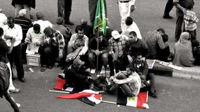 صورة لأشخاص يجلسون على علم مصر وويرفعون علم جماعة الإخوان تثير جدلا كبيرا