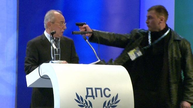بالصور| رجل يوجه سلاحه نحو زعيم حزب تركي بأحد المؤتمرات في بلغاريا