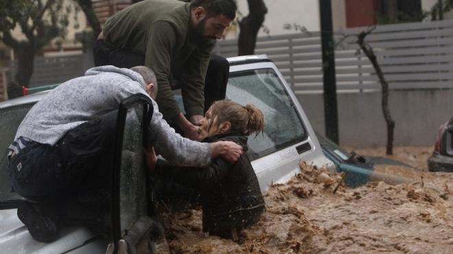  بالصور| إنقاذ امرأة أثناء انهمار أمطار غزيرة على أثينا.. في أسوأ عاصفة منذ 25 عاما