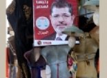 بالصور..أطرف أماكن الدعاية: مرسي يعتلي محلات الـ