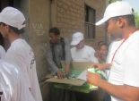  بالصور| لجنة الشباب بحملة السيسي توزع 10 آلاف لمبة موفرة في 5 قرى بقنا 