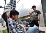بالصور|شاب ياباني يجلس أمام متجر 