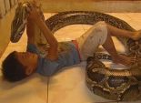 بالصور| صداقة قوية تجمع بين طفل كمبودي وثعبان طوله 5 أمتار 
